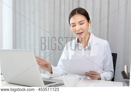 Young Asian women are talking friends and manager through video chats and greeting them with cheerfu