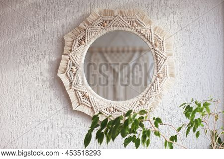 Macrame Mirror On A White Wall.  The Mirror Reflects Macrame Wallhanging. Eco-style. Natural Materia