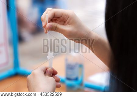Close-up Hand Holding Nasal Swap And Mix The Swap Mucus Sample And Extraction Solution In Tube Of An