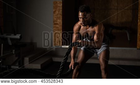 Attractive African American Man With Naked Torso Doing Endurance Exercises With Trope.