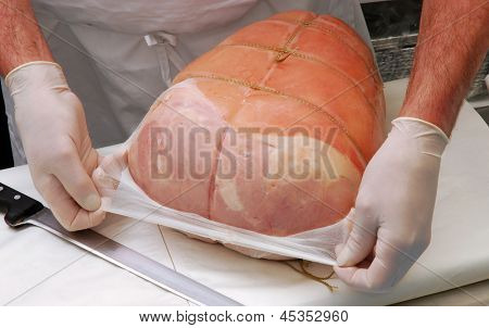Trabalhando em uma porção de presunto presunto de carne de açougue.