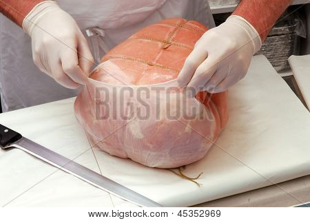 Trabalhando em uma porção de presunto presunto de carne de açougue.