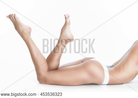 View Of Sexy Shaped Nude Female With Tanned Legs Posing Lying In White Panties Lingerie With Lifted