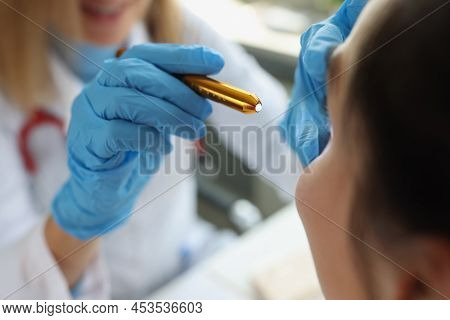 Doctor Neurologist Shining Flashlight On Patient Eyes In Clinic Closeup. Diagnosis Of Neurological D