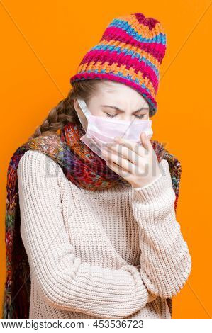 Healthcare Ideas.depressed Teenage Female Girl In Warm Knitted Hat And Scarf Using Facial Mask Again