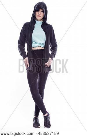 Full Length Portrait Of Sportive Caucasian Female Athlete Posing In Black Hoody And Sexy Fitness Out