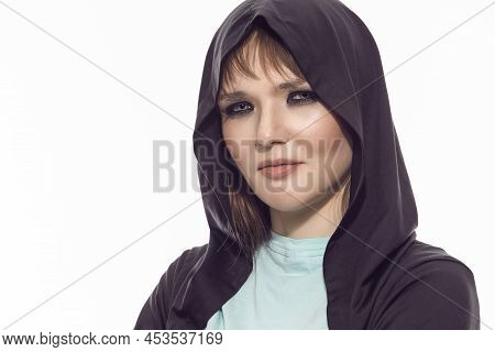 Closeup Portrait Of Positive Winsome Blond Caucasian Female Athlete In Black Hoody Posing With Folde