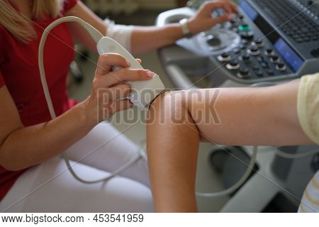 Doctor Making Ultrasound Of Patient Elbow Joint In Clinic Closeup. Instrumental Diagnosis Of Rheumat