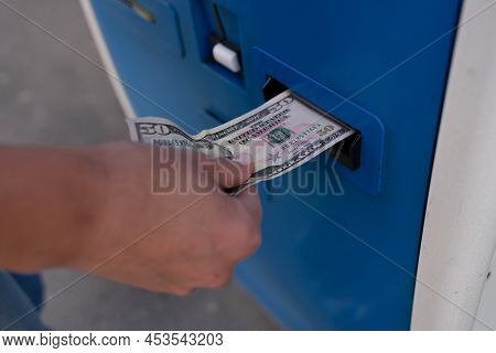 Woman Inserting Dollar Bills Into Atm On Street Closeup. Payment Concept