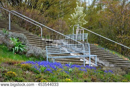 Between The Stairs Is A Waterfall With Stones And Boulders. Artificial Stream With A Waterfall Betwe