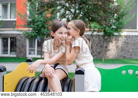 Kids Outdoors Having Fun On Modern Playground With New Colorful Equipment. Sisterhood, Friendship. T