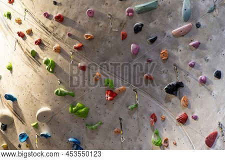 Artificial Rock Climbing Wall With Various Colored Grips.