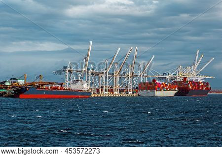 Ships Under Loading In The Seaport In The City Of Tsawwassen, Stormy Sea Dramatic Sky, Overcast