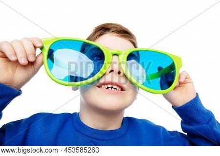 Funny Child In Big Eyeglasses Smiling And Looking Up. Happy Little Boy In Glasses Laughing Over Whit