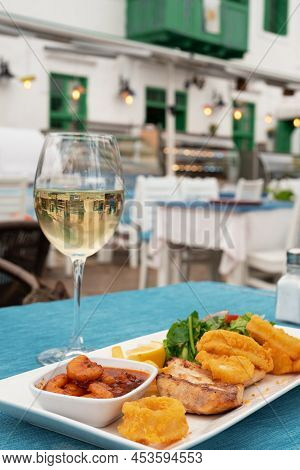 Delicious Grilled Seafood On Plate, Dish And Glass Of White Wine In Restaurant Outdoors.vertical Pho