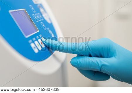 Close Up Laboratory Worker Hand In Rubber Gloves Sets Parameters On The Centrifuge For Sample Prepar
