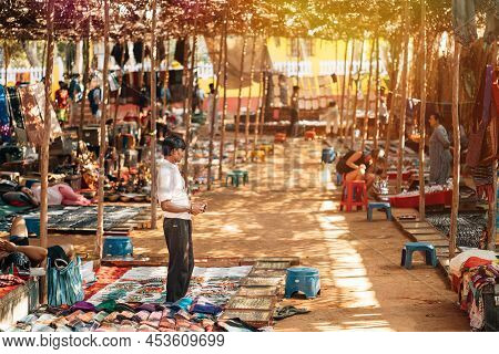 Anjuna, Goa, India - February 19, 2020: Man Seller Sells Indian Souvenirs In The Anjuna Market.