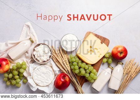 Shavuot Flat Lay With Dairy Products, First Fruits And Wheat On Light Gray Background. Jewish Shavuo