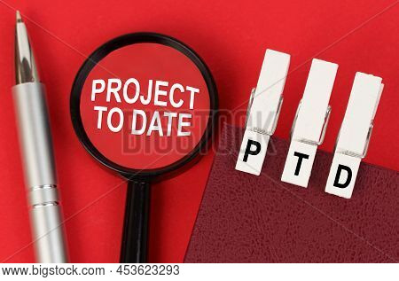 Business Concept. On The Red Surface Lies A Pen, A Notebook With Clothespins - Ptd, And A Magnifying