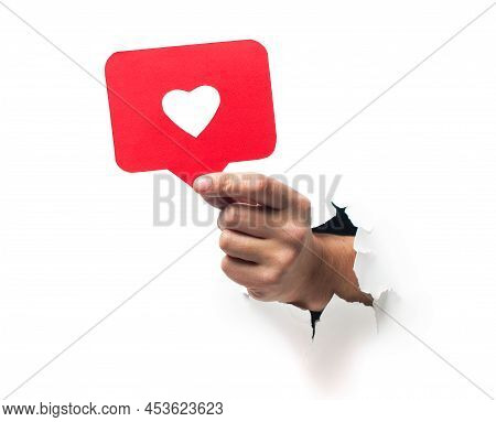 Man Hold Social Media Like, Demonstrates Approval Or Agreement Through Torn Paper Wall Yellow Backgr