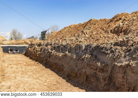 Dig A Trench. Earthworks, Digging Trench. Long Earthen Trench Dug To Lay Pipe Or Optical Fiber. Cons