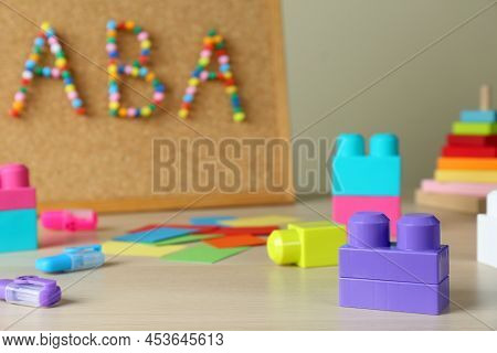 Cork Board With Abbreviation Aba (applied Behavior Analysis) At Table, Focus On Colorful Blocks