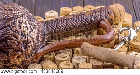 Clay Bottle, Metal Corkscrew And Cork On A Wooden Table