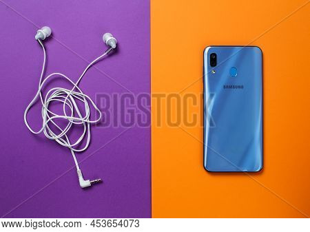 Zaporizhzhia, Ukraine - April 22, 2022: Samsung A30 Phone And Headphones.