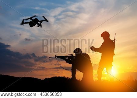 Silhouettes Of Soldiers Are Using Drone And Laptop Computer For Scouting During Military Operation.