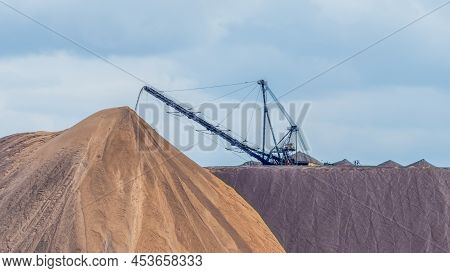 Giant Spreader Or Absetzer Machinery. A Large Dumper On A Landfill With Potash Ore. Extracting And M
