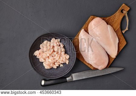 Brown Wooden Cutting Board With Pieces Of Chicken Breast Fillet And A Bowl Of Chopped Poultry Meat O