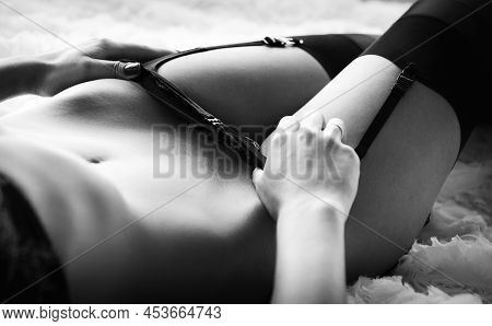 Close-up Of A Girl In Underwear Caressing Her Stomach With Her Hand While Lying On The Bed.