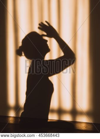 Shadow Or Silhouette Of A Woman Sitting With Her Hands Together Prayer Or Namaste Meditate In Sunset