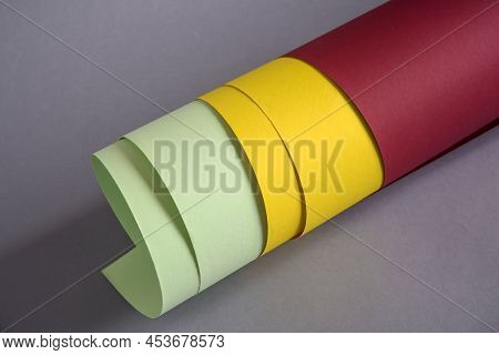 Rolled-up Colored Thick Paper Of Red, Yellow And Green Colors, On Gray Background. Close-up. Selecti