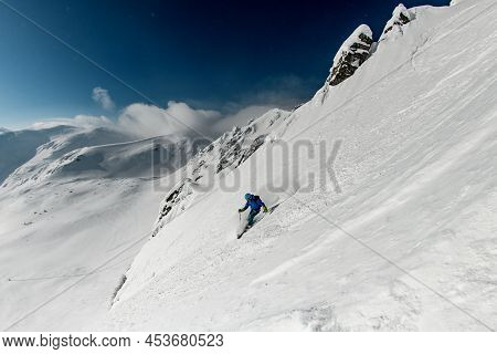 Male Freerider Skis Sideways Down On Snowy Mountain Slope