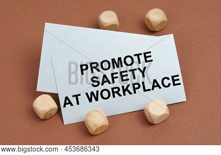 The Concept Of Industrial Safety. On A Brown Surface, Wooden Cubes And A Business Card With The Insc