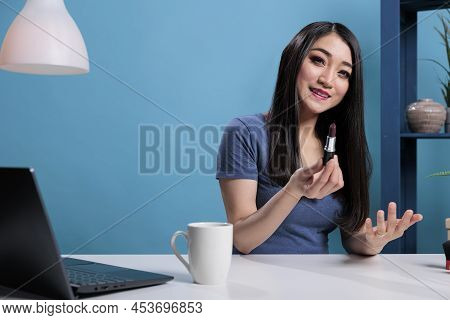 Portrait Of Asian Videoblogger Woman Holding Lipstick While Recording Makeup Review For Beauty Podca