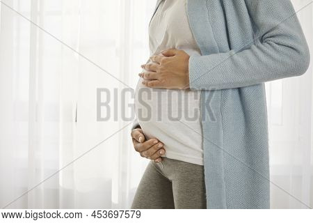 Close Up Of Pregnant Tummy Of Young Woman Who Is In Third Trimester Of Pregnancy.