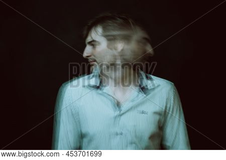 Schizophrenic Portrait Of Psychopathic Man With Mental Disorders In White Shirt On Dark Background