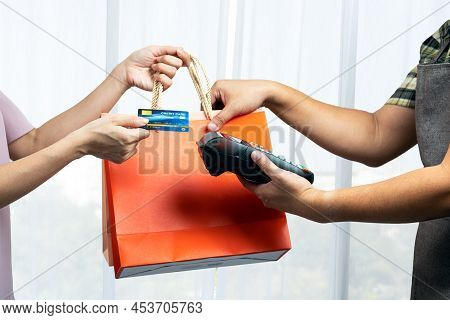 Unrecognizable Beautiful Woman Grap Shopping Bags And Pass Credit Card Doing Shopping With Retail St