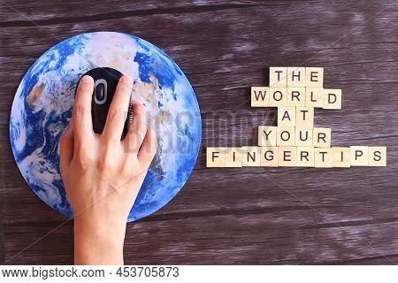 Hand Clicking Computer Mouse On Planet Earth Globe And Wooden Cube With Text The World At Your Finge
