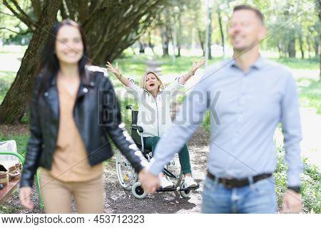Abandoned Disabled Woman Sits In Wheelchair In Park Stretches Arms Forward And Shouts No. Woman Man 