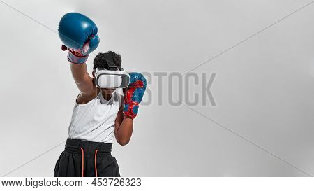 Partial Image Of Black Boy Boxer Wearing Vr Glasses Boxing. Male Child Wearing Sportswear And Boxing