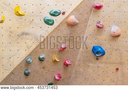 Artificial Rock Climbing Wall With Various Colored Grips.