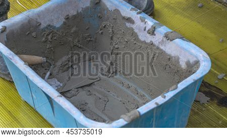 A Worker Kneads The Mixture Into Plaster Buckets. A Container With Mixed Plaster For Wall Repair. Ov