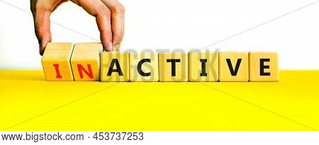 Active Or Inactive Symbol. Businessman Turns Wooden Cubes And Changes The Word Inactive To Active. B