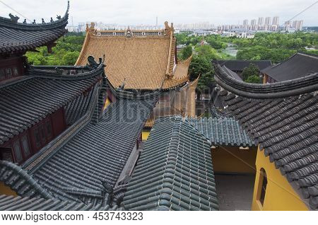 Looking Out Over The Roof Tops Of The Jinshan Temple With The City Of Zhenjiang In The Background On