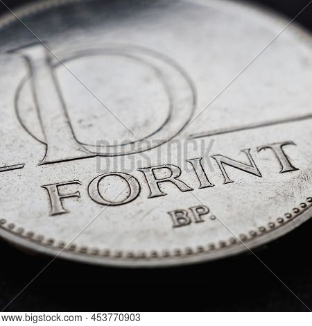 Hungarian Coin Of 10 Forints Lies On A Dark Black Surface Close-up. Money Of Hungary. News About Eco