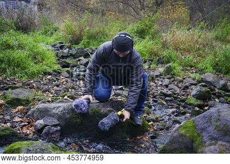 The Guy Is Holding A Microphone Gun In His Hand. Recording Nature Sounds. Hand Holds A Microphone Gu