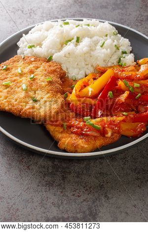 German Schnitzel Served With Paprika Sauce And Rice Close-up In A Plate On The Table. Vertical